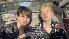 two young men sitting in the back seat of a car, one with blonde hair