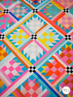 a colorful quilt with squares and triangles on it