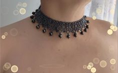 a woman wearing a black choker with pearls on it's neck and necklace