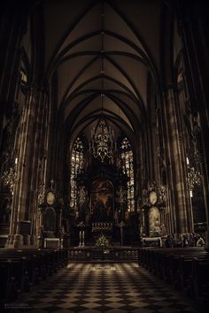 the interior of a gothic church with stained glass windows and black and white checkered floor