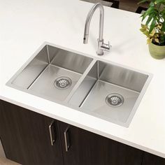 two stainless steel sinks in a white counter top