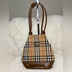 Description Burberry's Bucket Bag Vintage Brown Canvas Plaid Print Gold-Tone Hardware Dual Shoulder Straps Leather Trim Embellishment Canvas Lining & Dual Interior Pockets Snap Closure At Top Details: Depth: 5" Width: 8.75" Shoulder Strap Drop: 10" Height: 10.5" This Item Is Vintage And Is Authentic. Minor Rubs At The Bottom Piping And One Light Scratch As Seen In Picture. Inside Is Clean And No Stain Noted. Burberry Horseferry Bag, Burberry Bucket Bag, Burberry Handbags, Brown Canvas, Plaid Print, Vintage Brown, Burberry Bag, One Light, Leather Trims