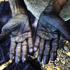 the hands of a man with black paint on them