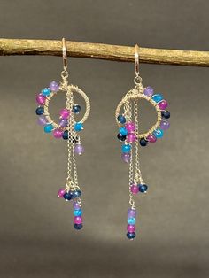 Artisan designed and handcrafted one of a kind  Blue Sapphire, Blue Jasper, Red Purple Jade, lavender amethyst and Light Purple Jade gemstone beaded earrings.  The faceted round 3/4 inch hoops is wire wrapped with 4 mm gems. This is a incredible mixture of shiny silver and multiple colorful gemstones, faceted hoop, and Sterling silver chain, dangling Chandelier earrings. These earrings reminds me of dream catchers. The colors in this dazzling earrings are spectacular and would make a wonderful g Gem Hoop Earrings, Purple Wire Wrapped Chandelier Drop Earrings, Multicolor Dangle Chandelier Earrings For Celebration, Handmade Purple Earrings For Celebration, Fusion Style Multicolor Dangle Chandelier Earrings, Multicolor Fusion Dangle Chandelier Earrings, Dangling Chandelier, Colorful Gemstones, Beaded Stuff