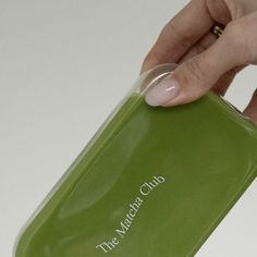 a hand holding a green plastic case with the words the water club on it's side