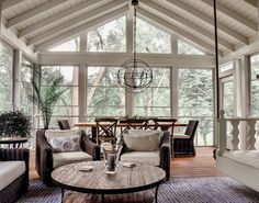 a living room filled with lots of furniture and a wooden table in the middle of it