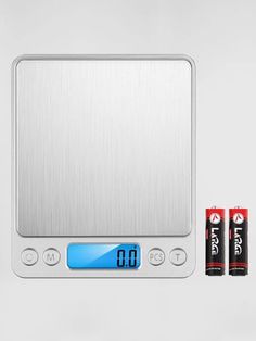 two batteries are sitting on top of a scale and one battery is in front of the scale