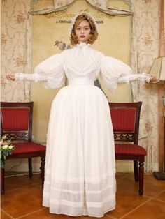 This price includes a blouse, a skirt, and a sash.  This set has a Victorian-era day dress inspiration. Dress / Top Details:Lace TrimNeckline:High Neck / Ruffle NecklineSkirt Details:Flounce Hem Skirt / LinedSleeves:Leg-of-Mutton Sleeves This is the size chart for the blouse.   	 		 			Size 			XS 			S 			M 			L 			XL 		 		 			Bust 			82 			86 			90 			94 			98 		 		 			Waist 			64 			68 			72 			76 			80 		 		 			Sleeve Length 			58 			58 			60 			60 			62 		 		 			Full Length 			58 			58 			60 Historical Design Vintage Dress For Events, Victorian Style Vintage Dress For Costume, Victorian Vintage Dress For Costume, Classic Vintage Dress For Vintage Events, Historical Design Prairie Dress For Wedding, Wedding Prairie Dress With Historical Design, Victorian Long Sleeve Dress With Historical Design, Fitted Vintage Victorian Dress With Doll Collar, Victorian Dress With Long Sleeves And Historical Design