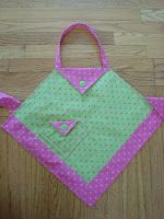 a pink and green bag sitting on top of a wooden table