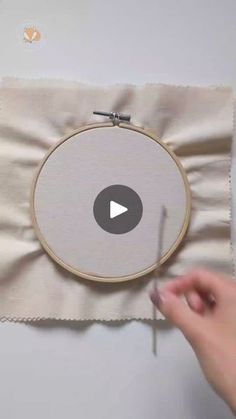 someone is stitching on the fabric to make a cross - stitch project with scissors