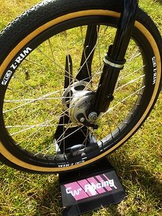 a close up of a bike tire on the ground with grass in the back ground