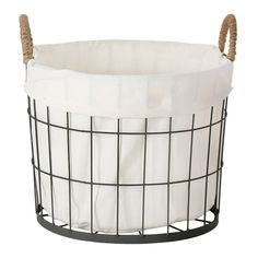 a black wire basket with white fabric inside