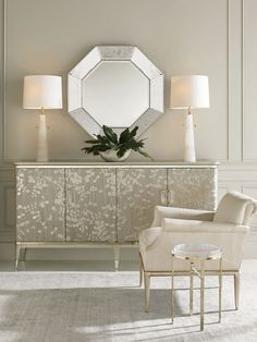 an elegant living room with white furniture and large mirrors on the wall above it's headboard