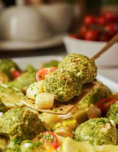 broccoli and other vegetables are being held by a spoon