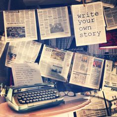 an old typewriter sitting on top of a wooden desk next to many newspapers