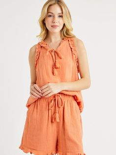 Summer style just got a playful upgrade with our Matchy Matchy Gauze Set in Coral Orange! Made from light and breezy gauze fabric, this set includes a sleeveless top with matching shorts for a coordinated look. The stylish details of tassels and ruffles add a fun touch to the coral orange color. Perfect for any sunny day! Color: Coral Orange Fabric: 100% Polyester Includes: x1 Top and x1 Bottom (Matching Set) Sizes: S-M-L, Regular Sizing. Summer Ruffle Set With Shorts, Summer Ruffled Short Sets, Sleeveless Ruffled Beach Set, Summer Sets With Ruffles And Sleeveless Design, Summer Ruffled Short Tops, Summer Bohemian Sleeveless Sets, Sleeveless Summer Sets For Day Out, Bohemian Sleeveless Sets For Beach Season, Spring Vacation Sleeveless Sets