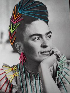 a black and white photo of a woman with colorful hair pins on her head, looking at the camera