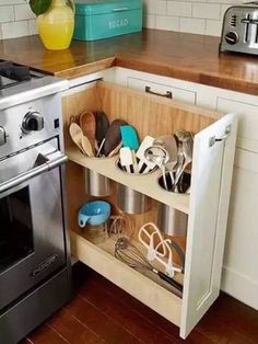 a kitchen with an oven, dishwasher and utensils in the drawer