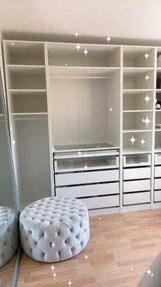 a bedroom with white furniture and lights on the wall above it, along with an ottoman