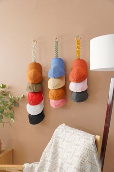 three hats are hanging on the wall next to a lamp and a chair in a room