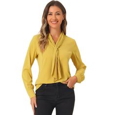 It features a classic design with a tie and long sleeves with button cuffs, creating a fitted silhouette, especially for work or office. Designed in a fluid, flowing fabric that drapes beautifully around the body. Offering effortless style, the blouse falls beautifully on the body and features a subtly pleated design to add to the delicate nature. A tie front design creates a feminine finish on this shirt, an everyday staple for the office. Style it with your favorite jeans and heels for a styli Solid Tie Neck Blouse For Work, Professional Long Sleeve Blouse For Office Wear, Professional Long Sleeve Business Casual Blouse, Long Sleeve Office Lady Blouse For Business, Long Sleeve Office Blouse For Business, Long Sleeve Business Blouse, Fall Office Lady Blouse For Business Casual, Fall Office Lady Blouse For Business, Fall Business Blouse For Office Ladies