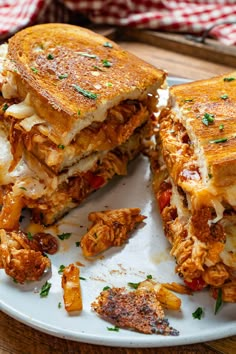 a white plate topped with a cut in half sandwich on top of a wooden table