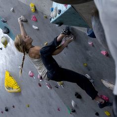 a woman climbing up the side of a rock wall