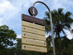 a street sign in front of some palm trees