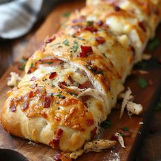 a cheesy bread with bacon and cheese on a cutting board