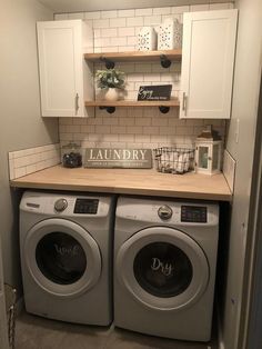 a washer and dryer in a small laundry room with white cabinetry, open shelving above the washer and dryer