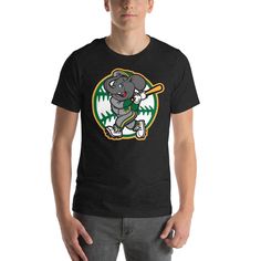 Celebrate your love for the Oakland Athletics with this unique T-shirt featuring the team's iconic elephant mascot! The design is an original fan-inspired creation, featuring the A's elephant in green and gold colors. Made from high-quality cotton, this tee is soft, comfortable, and perfect for showing your team pride on game days or any day. Features: Original fan-inspired design featuring the Oakland Athletics elephant High-quality cotton material Short sleeves for a comfortable fit Available in a range of sizes for men, women, and kids Note: This T-shirt is not officially licensed by the MLB or Oakland Athletics, but is an original fan design that does not infringe on any copyrights or trademarks. * 100% cotton * Ash is 99% cotton, 1% polyester * Sport Grey is 90% cotton, 10% polyester Elephant Mascot, Elephant Shorts, Kids Notes, Fan Design, Unique T Shirt, Gold Colors, Oakland Athletics, Unique Tshirts, Green And Gold