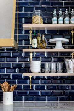 the shelves in this kitchen are filled with bottles and bowls, cups, spoons and utensils