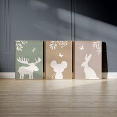 three canvases with animals on them are sitting in front of a wall and floor