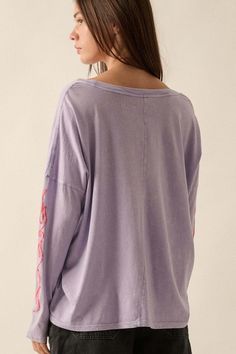 Mineral washed graphic t-shirt. Vintage-style "But She's Hot" text print with flame graphics. Long sleeves with flame print. Dropped shoulder. Round neckline. Center-back seam. Oversized fit. 100% Cotton. Imported top designed and printed in LA. Model wears size S. Acid Wash Washed Tops For Fall, Oversized Long Sleeve Lavender Top, Spring Oversized Purple Tops, Oversized Purple Tops For Spring, Distressed Graphic Tee With Long Sleeves, Lavender Top For Spring Streetwear, Summer Soft-washed Purple Tops, Purple Graphic Print Tops For Loungewear, Oversized Purple Lounge Top