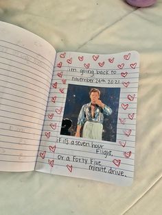 an open notebook with a photo of a woman on it and hearts drawn all over the pages