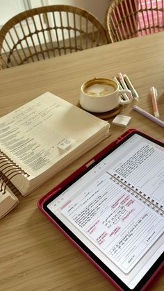 a tablet computer sitting on top of a wooden table next to a cup of coffee