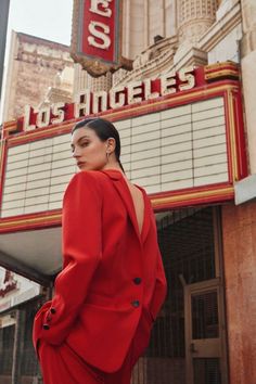 a woman standing in front of a marquee with the words los angeles written on it