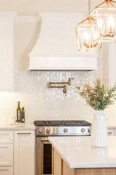 a white kitchen with an oven, sink and wine rack on the wall above it