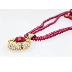 This is part of Chairish’s Fine Jewelry assortment.  This captivating pendant necklace, showcases a mesmerizing 22.41 carat, deep pink ruby cabochon cut, securely set in a classic bezel mounting crafted from 18k yellow gold. The weight of the piece is 27.57 grams. GRS certified, the ruby is surrounded by 144 sparkling diamonds and further complemented by 7 elegant emerald cut diamonds, totalling approximately 13-15 carats. A beaded ruby chain completes this luxurious and unique statement piece. Diamond Cabochon Pendant Necklace, Luxury Round Cabochon Necklace, Luxury Cabochon Round Pendant Necklaces, Luxury Cabochon Round Pendant Necklace, Luxury Round Pendant Necklaces With Cabochon, Luxury Round Pendant Necklace With Cabochon, Luxury Red Cabochon Necklaces, Luxury Red Cabochon Necklace, Ruby Cabochon Pendant Jewelry