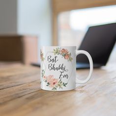 a white coffee mug sitting on top of a wooden table