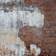 an old brick wall with peeling paint on it