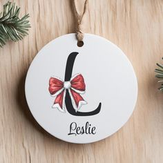 a personalized christmas ornament with a red bow and the letter j on it