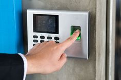 a person is pressing the button on an electronic door lock with a green light in front of them