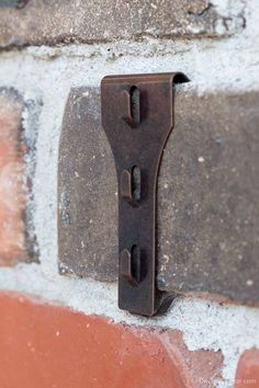 a metal hook on the side of a brick wall