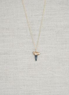 Real Shark Tooth Necklace Dipped in Gold This minimalist gold shark tooth necklace is simply beautiful and features a real fossilized shark tooth found by Foxy Fossils in Charleston, SC hand-dipped in gold and carefully wire-wrapped into a genuine prehistoric pendant. Whether you wear your shark tooth necklace alone or paired with your other favorite necklaces, you can always take a piece of the ocean with you in this signature piece! Details: Length: 16" or 18" Dainty 14K gold-filled chain and Shark Conservation, Beachy Necklace, Fossil Hunting, Shark Earrings, Teeth Shape, Shark Tooth Necklace, Cute Piercings, Tooth Necklace, Fossil Jewelry