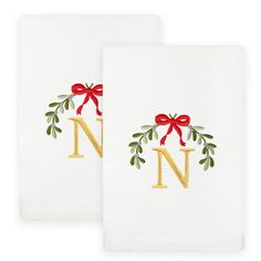 two white towels with red bows and the letter n in gold on each towel is embroidered onto it