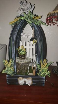 a wooden table topped with a cake covered in succulents next to a white fence