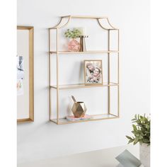 three shelves with pictures and vases on them against a wall in the corner of a room