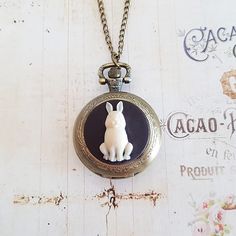 A fully working bronze pocket watch with a detailed charcoal and cream rabbit cameo in the centre is suspended on a long antiqued bronze chain. Choose your length from the drop down menu. The necklace is antiqued bronze with a lobster clasp. The watch is 1 3/8 inches (35 mm) in diameter, and pops open when you press the button at the top. (there's protective film to remove when you receive it). A battery is already inside the watch. This necklace is gift boxed. White Rabbit Pocket Watch, Watch Diy, Rabbit Necklaces, Pocket Watch Necklace, Cameo Necklace, Oval Earring, White Rabbit, Hammered Silver, Watch Necklace