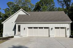 a white house with two garages in the driveway